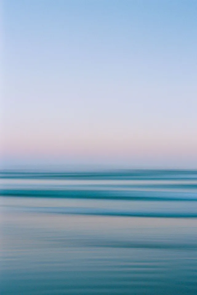 Blurred long exposure of blue sea under a pastel sky