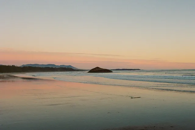 Calm beach at dusk with a small island offshore